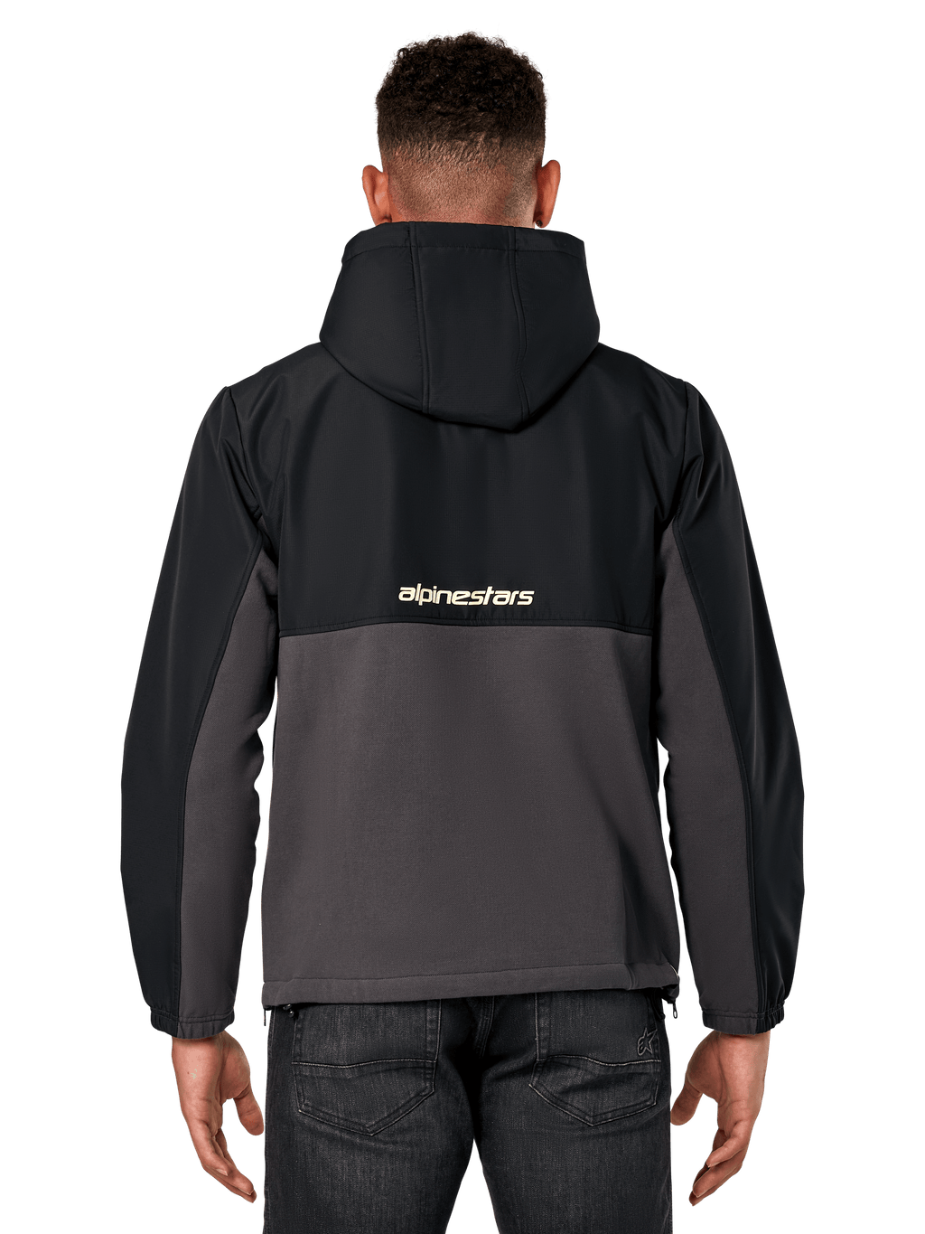 Kurtka Alpinestars Juncture Hybrid, widok z tyłu, czarny i gunmetal, casualowy anorak z mieszanych materiałów, góra z ripstopu i dół z polaru płóciennego, logo Alpinestars na plecach, noszona z ciemnymi spodniami