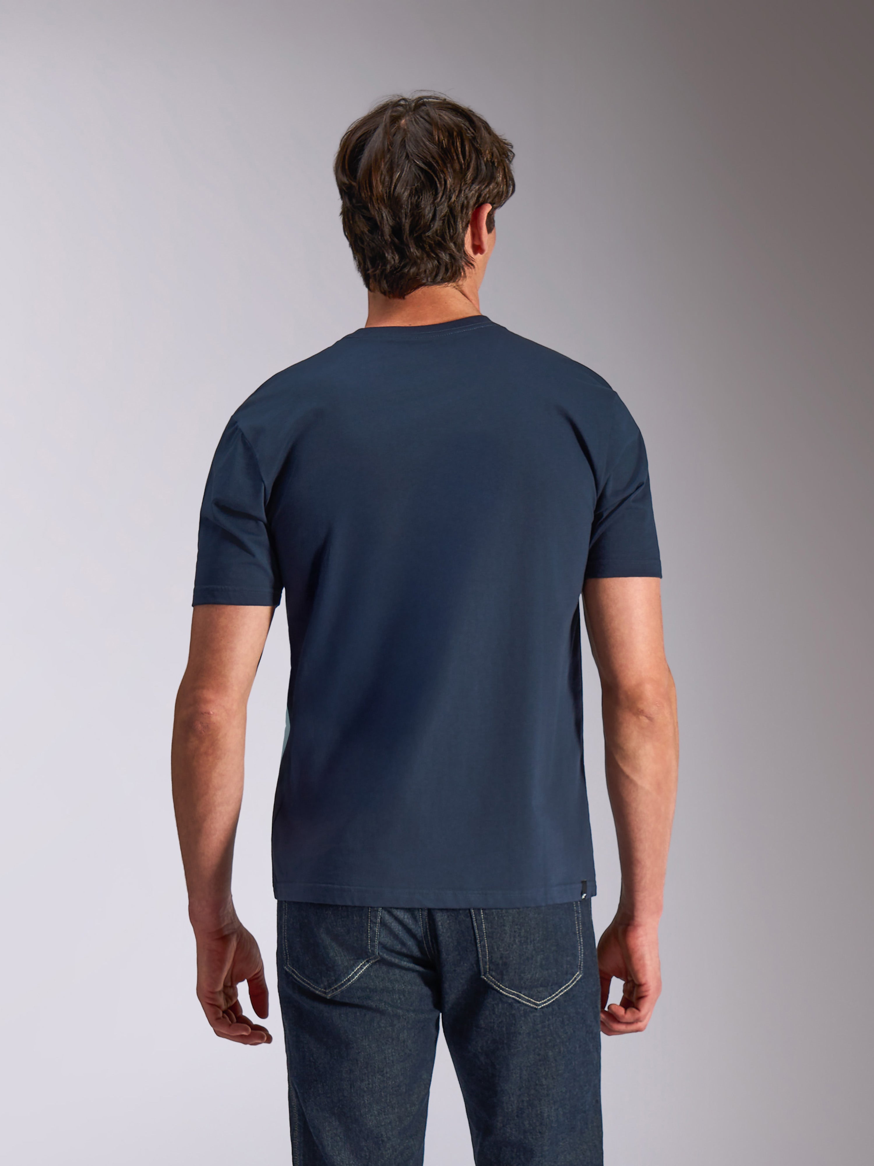 Alpinestars Ageless Shadow CSF Tee, koszulka z krótkim rękawem, granatowa, widok z tyłu, model w ciemnych dżinsach, codzienna odzież lifestylowa motorsport
