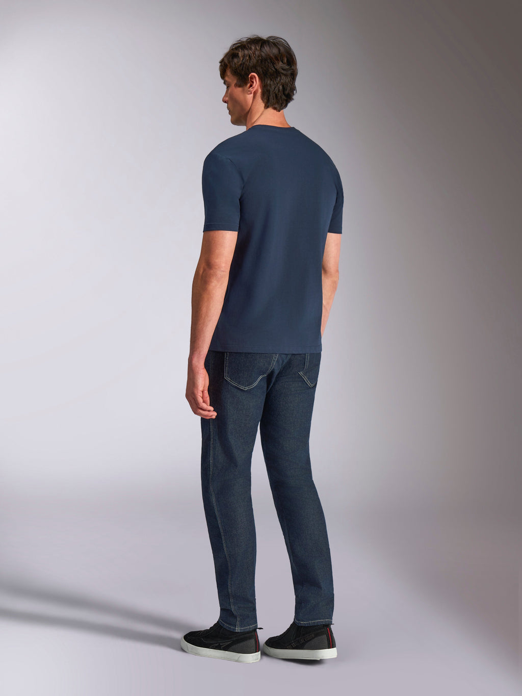 Alpinestars Ageless Shadow CSF Tee, koszulka z krótkim rękawem, granatowa, widok z tyłu na modelu, noszona z ciemnymi jeansami i czarnymi sneakersami, casualowy styl streetwear