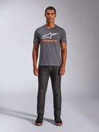 Alpinestars Always 2.0 CSF Tee, t-shirt z krótkim rękawem, grafitowy z białym logo i pomarańczowym napisem, prezentowany przez modela w ciemnych dżinsach, codzienna odzież streetwearowa w stylu motorsportowym