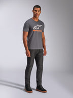 Alpinestars Always 2.0 CSF Tee, koszulka z krótkim rękawem, grafitowa, białe logo A-star z pomarańczowym brandingiem, casualowa odzież streetwearowa w stylu motorsport noszona z ciemnymi jeansami i czarnymi sneakersami