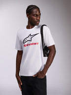 Alpinestars Always 2.0 CSF Tee, koszulka z krótkim rękawem, biała, czarne logo z gwiazdą i czerwony napis Alpinestars, prezentowana przez modela z czarną torbą typu crossbody, odzież sportowa typu casual motorsport