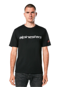 Koszulka Alpinestars Linear Wordmark 2.0 CSF, t-shirt z krótkim rękawem, czarny, szary linearny znak słowny na klatce piersiowej i czerwone logo Ageless na rękawie, noszona przez modela z ciemnymi jeansami, casualowy streetwear inspirowany sportami motorowymi