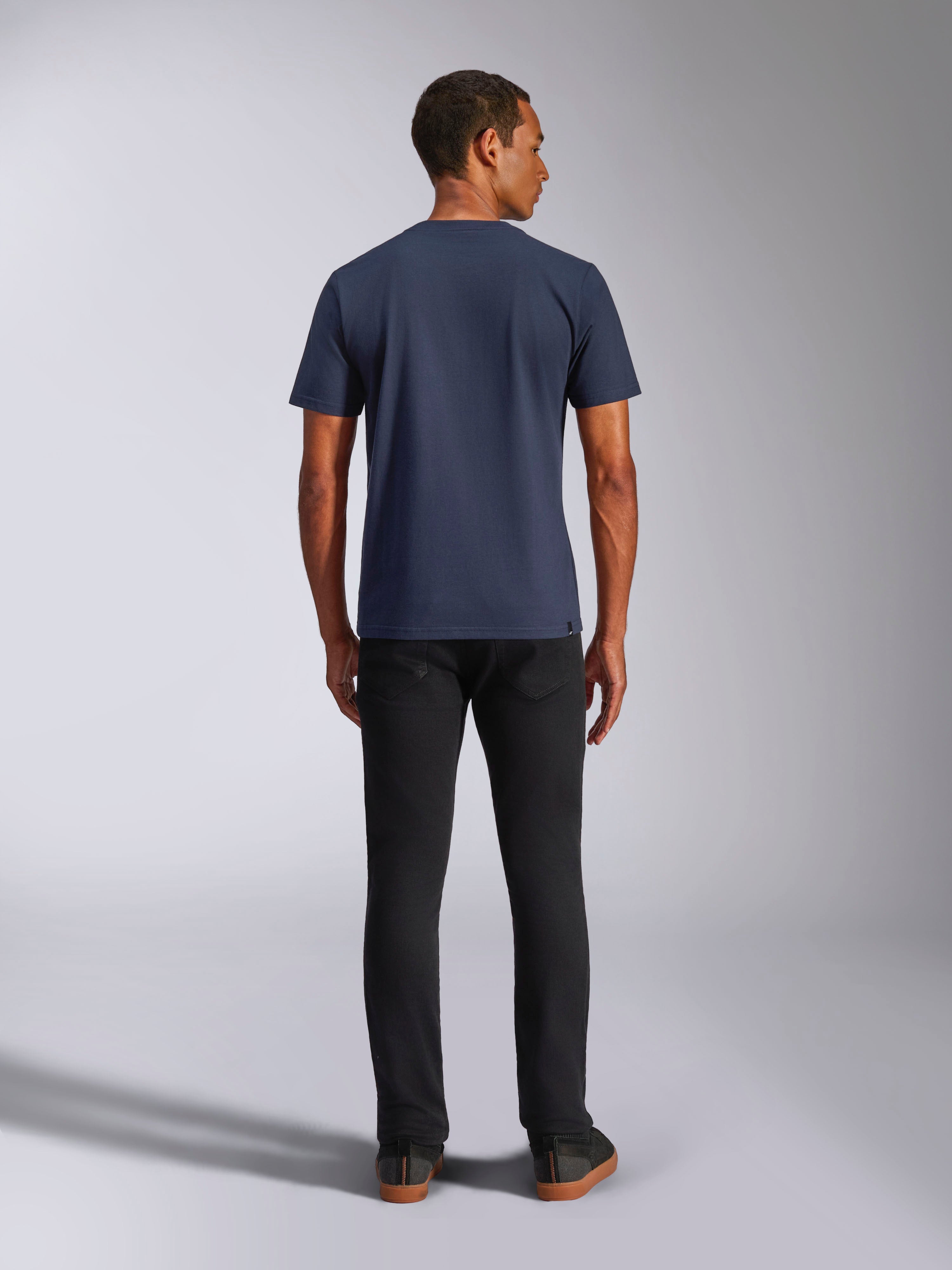 Alpinestars Ride 4.0 CSF Tee, koszulka z krótkim rękawem, granatowa, widok z tyłu na modelu, w zestawieniu z czarnymi jeansami, codzienna odzież streetwearowa inspirowana sportami motorowymi