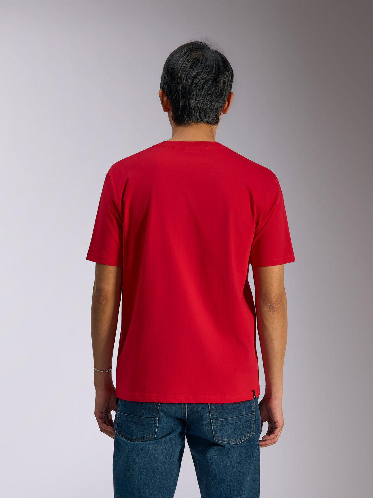 Alpinestars Ageless Shadow CSF Tee, widok z tyłu, koszulka z krótkim rękawem, czerwona, codzienna odzież typu motorsport, noszona z niebieskimi dżinsami
