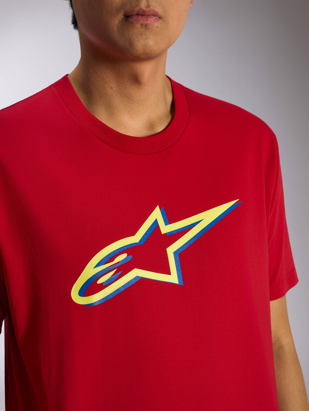 Alpinestars Ageless Shadow CSF Tee, koszulka z krótkim rękawem, czerwona, żółta i niebieska grafika z logo Ageless Shadow, zbliżenie na modelu, codzienna odzież streetwearowa w stylu motorsportowym