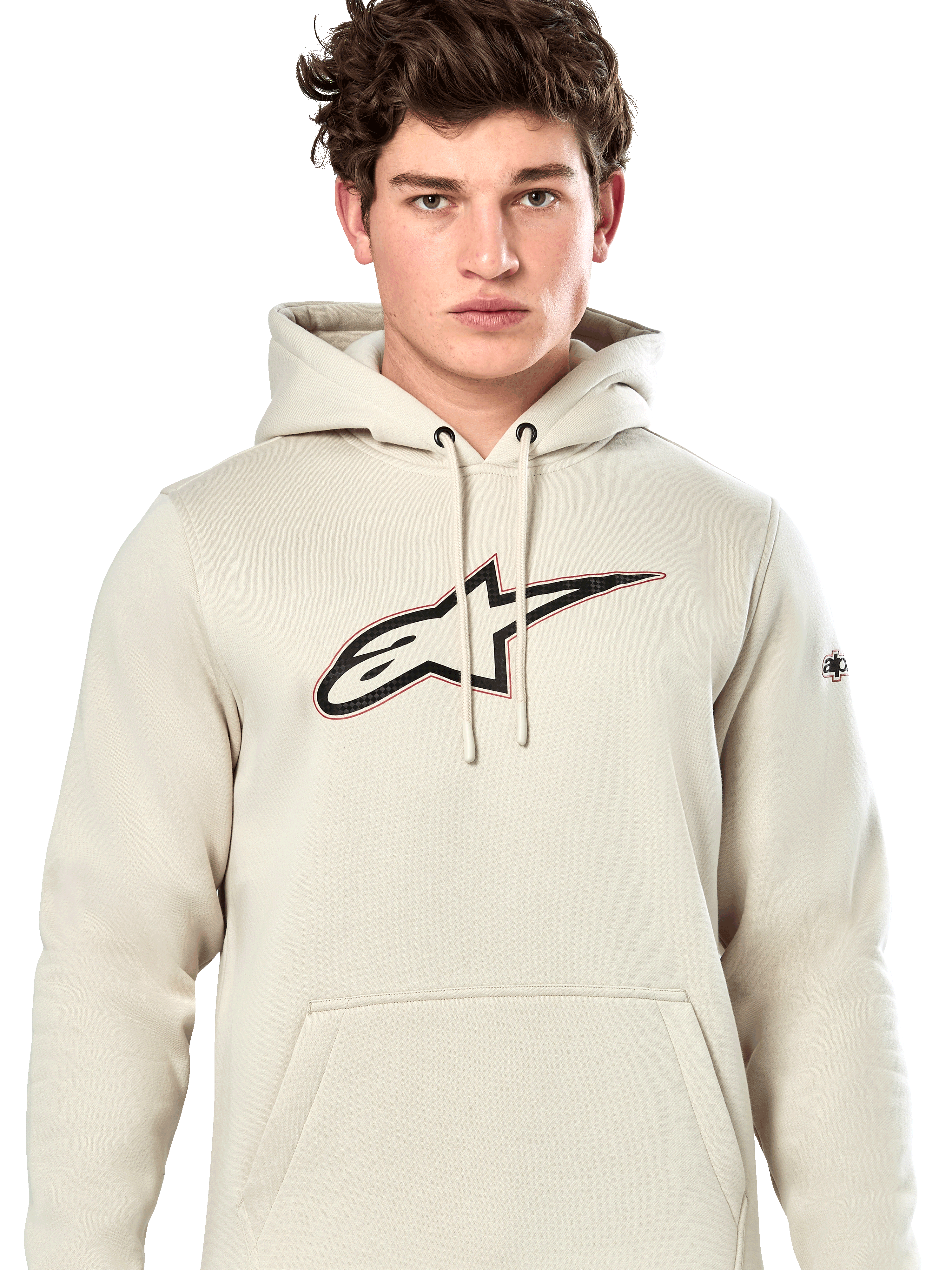 Alpinestars Insignia Hoodie, codzienna bluza z kapturem typu pullover, kolor złamanej bieli (Off White) z logo o wyglądzie włókna węglowego na piersi i czerwonym konturem, kaptur ze sznurkami i kieszeń kangurka, noszona przez modela, design inspirowany sportami motorowymi