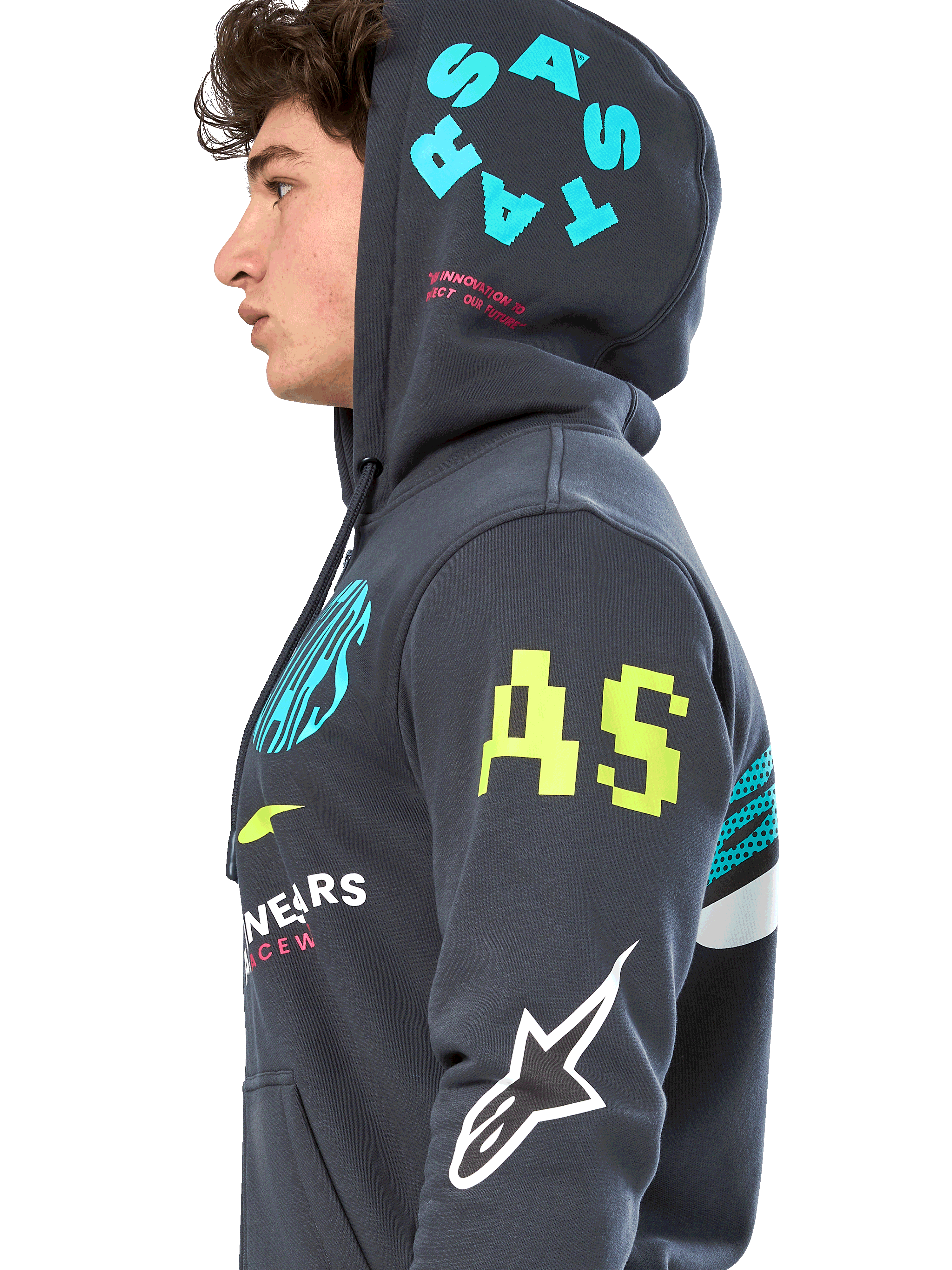 Bluza z kapturem Alpinestars Variegate, ciemnoszara polarowa bluza z zamkiem z przodu, profil boczny modelu, wielokolorowe grafiki z logo w kolorze neonowożółtym, jasnoniebieskim i białym, logo „AS” na rękawie i napis „STARS” na kapturze, codzienna odzież uliczna inspirowana sportami motorowymi