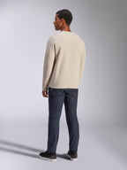 Alpinestars Positive Crew, bluza typu crewneck w kolorze złamanej bieli, widok z tyłu na modelu, w zestawieniu z ciemnymi jeansami i czarnymi sneakersami, casualowa odzież uliczna w stylu motorsport, ze ściągaczami przy mankietach i na dole