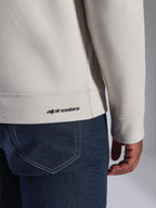 Bluza Alpinestars Positive Crew, Off White, zbliżenie na prążkowany dół i mankiet, z małym czarnym logo Alpinestars, codzienna odzież inspirowana sportami motorowymi