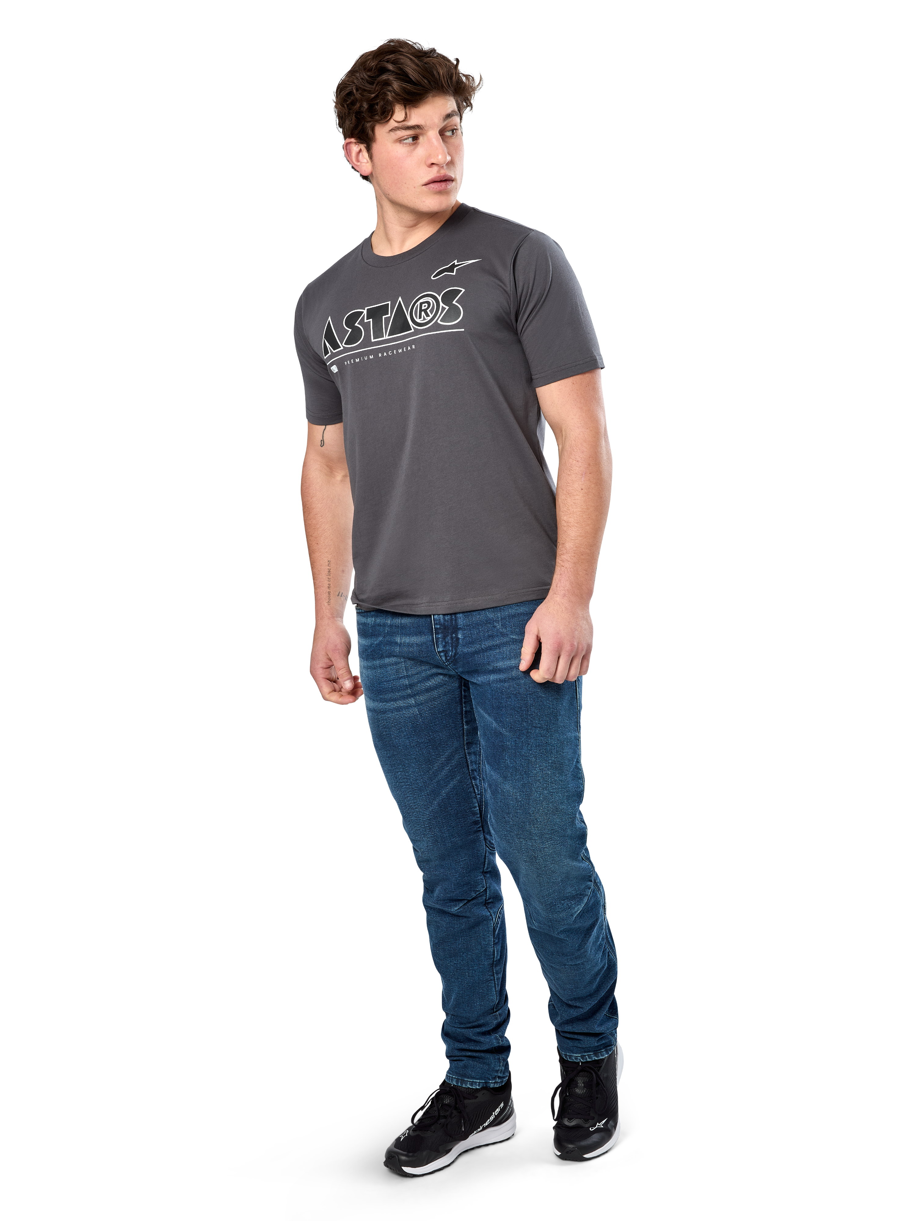 Alpinestars Cereal CSF Tee, koszulka z krótkim rękawem, grafitowa, białe geometryczne logo tekstowe Astars, codzienna odzież streetwearowa w stylu motorsport noszona z niebieskimi jeansami i czarnymi sneakersami