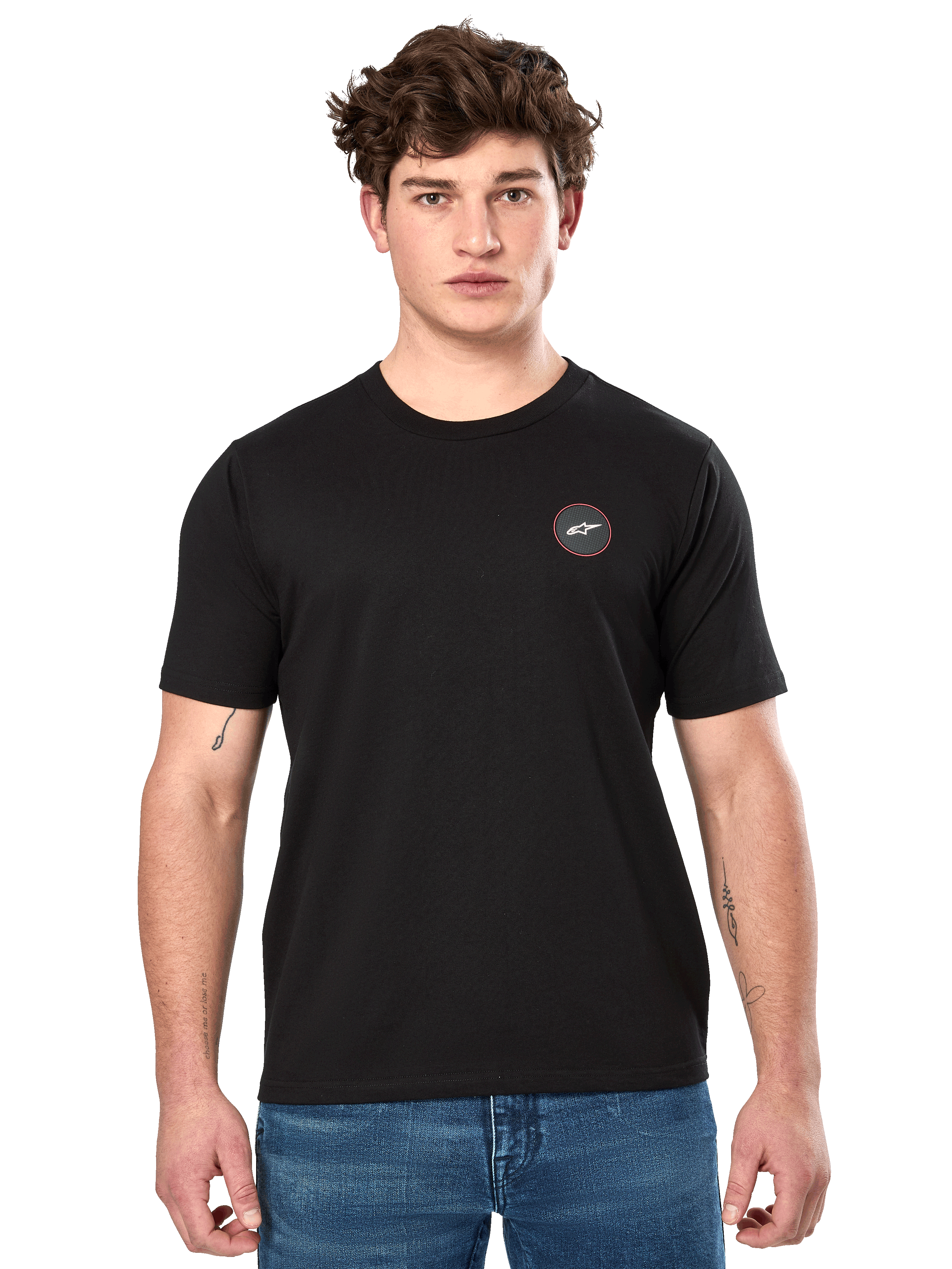 Alpinestars Dot Carbon CSF Tee, czarna koszulka z krótkim rękawem, małe okrągłe logo na piersi z białą gwiazdą Astar i czerwoną obwódką, noszona przez modela w niebieskich dżinsach, codzienna odzież motorsportowa typu streetwear