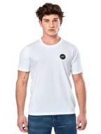 Alpinestars Dot Carbon CSF Tee, biała koszulka z krótkim rękawem, męski model w białej koszulce z małym czarnym okrągłym logo na piersi i niebieskich jeansach, casualowy styl motorsportowy