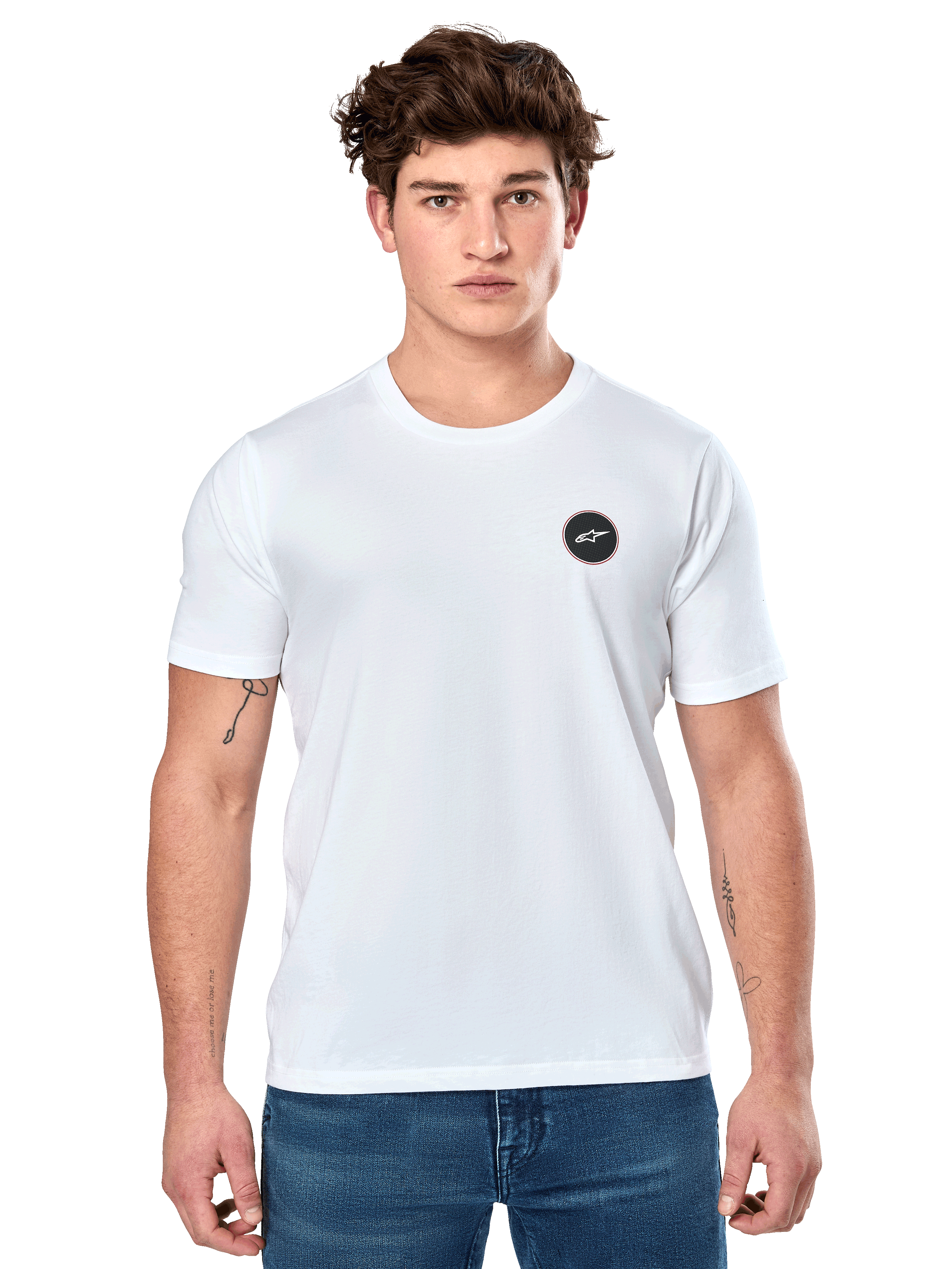 Alpinestars Dot Carbon CSF Tee, biała koszulka z krótkim rękawem, męski model w białej koszulce z małym czarnym okrągłym logo na piersi i niebieskich jeansach, casualowy styl motorsportowy