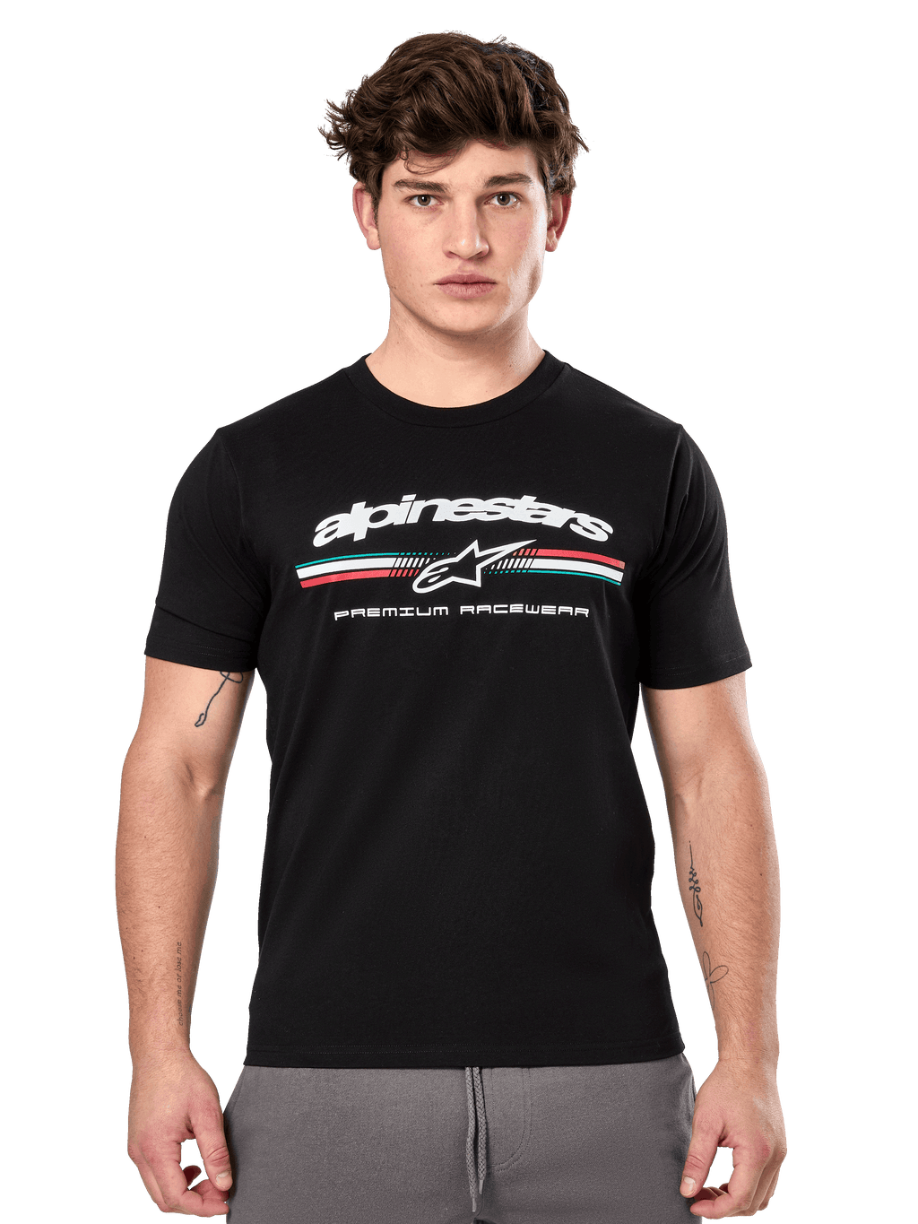 Alpinestars Prevail CSF Tee, czarna koszulka z krótkim rękawem prezentowana przez modela, białe logo z trójkolorowym paskiem i grafiką „PREMIUM RACEWEAR”, codzienna odzież uliczna w stylu motorsport