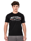 Alpinestars Prevail CSF Tee, czarna koszulka z krótkim rękawem prezentowana przez modela, białe logo z trójkolorowym paskiem i grafiką „PREMIUM RACEWEAR”, codzienna odzież uliczna w stylu motorsport