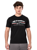 Alpinestars Prevail CSF Tee, czarna koszulka z krótkim rękawem prezentowana przez modela, białe logo z trójkolorowym paskiem i grafiką „PREMIUM RACEWEAR”, codzienna odzież uliczna w stylu motorsport
