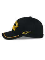 Alpinestars Luminary Hat, czarna czapka snapback widoczna z boku, żółty haft 3D z przodu i z boku, zakrzywiony daszek z żółtą lamówką sutache, usztywniona konstrukcja z bawełnianego kepru