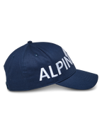 Alpinestars Committed Hat, granatowa czapka z daszkiem typu snapback, widok z boku z dużym białym haftowanym napisem, strukturalna korona z zakrzywionym daszkiem, wytrzymała tkanina twill, codzienne nakrycie głowy w stylu motorsportowym