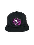 Alpinestars That Way Trucker Hat, czarna czapka typu trucker, fioletowo-czarna naszywka graficzna z napisem „One Vision One Goal”, płaski daszek, usztywniona korona i siateczkowe panele z tyłu, codzienne nakrycie głowy inspirowane sportami motorowymi