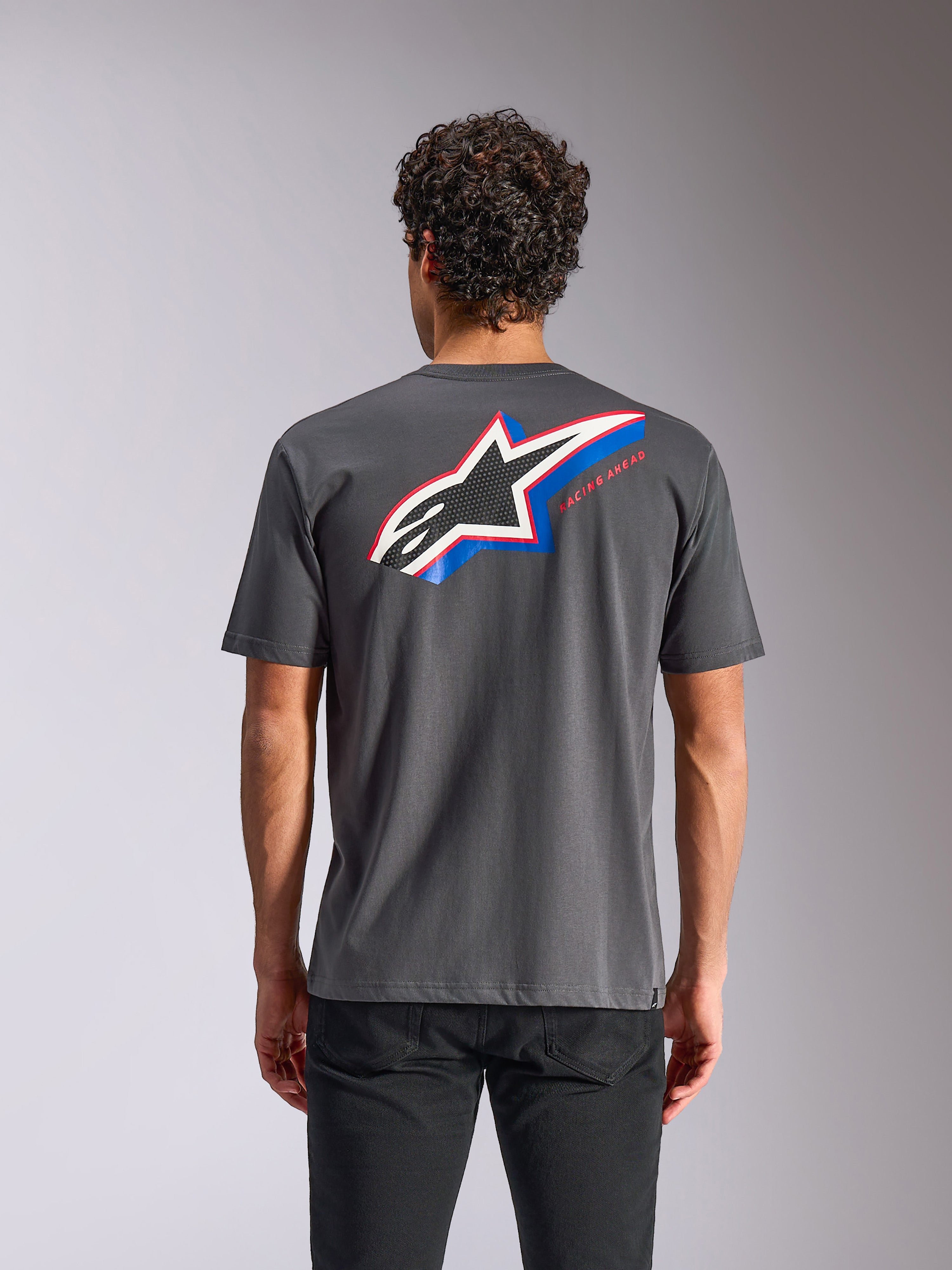 Alpinestars Angler CSF Tee, koszulka z krótkim rękawem, grafitowa, widok z tyłu z dużym logo Astars z niebieskimi i czerwonymi akcentami oraz napisem „RACING AHEAD”, codzienna odzież streetwearowa w stylu motorsportowym