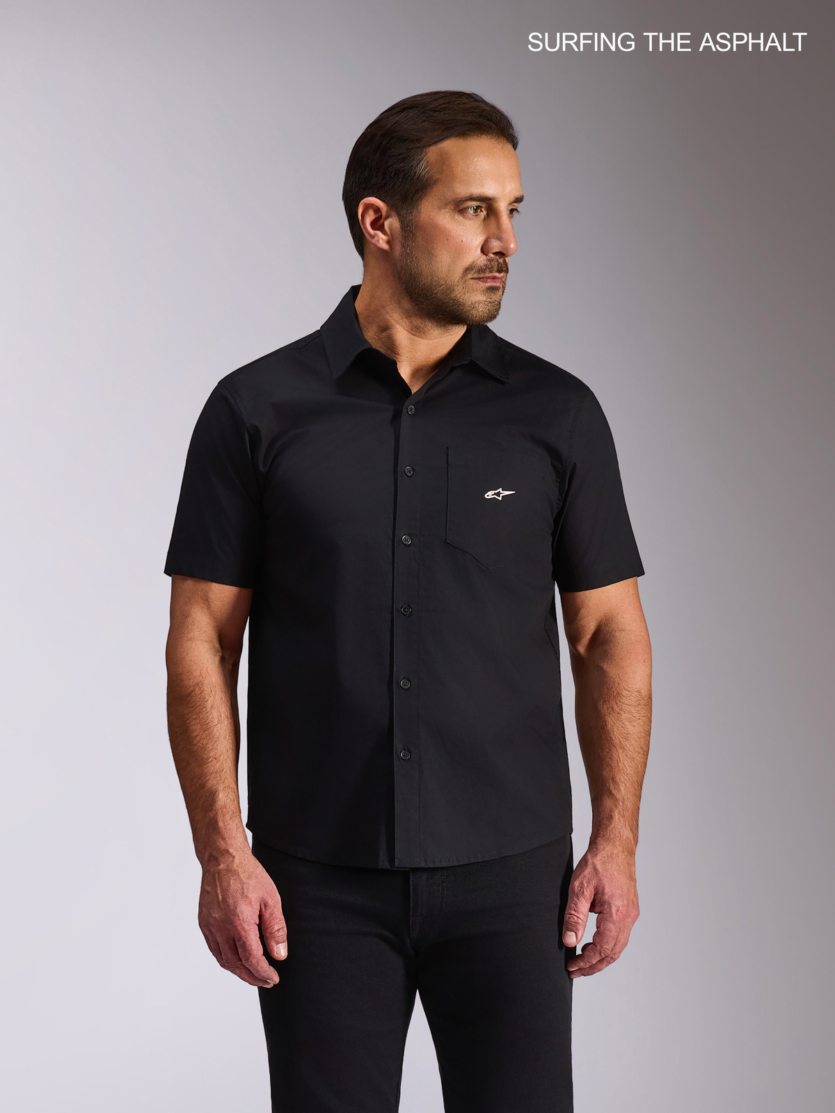 Alpinestars Strive Woven, czarna koszula casual z krótkim rękawem dla mężczyzny, elastyczna tkanina poplinowa, kieszeń na piersi z białym logo