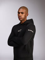 Alpinestars Insight Hoodie, sportowa bluza z kapturem, czarna, białe logo Astars na piersi i logo z napisem na górnym rękawie, model w bluzie ze skrzyżowanymi rękami, konstrukcja z wysokiej jakości dwustronnego polaru