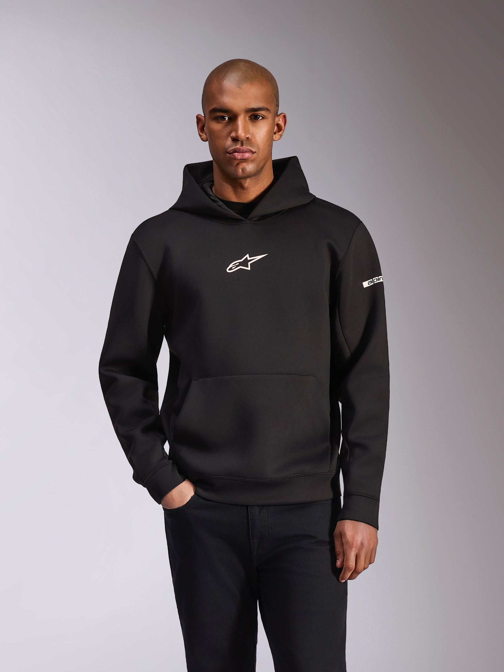 Alpinestars Insight Hoodie, czarna bluza z kapturem typu pullover, białe logo Astars na klatce piersiowej i napis na rękawie, kieszeń typu kangurka, dwustronny polar tri-blend, codzienna odzież motorsportowa w stylu streetwear