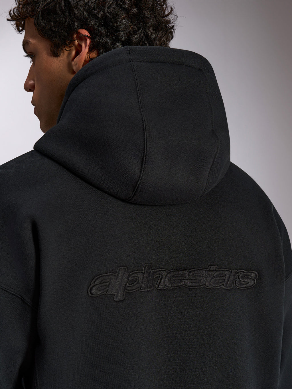 Alpinestars Emergent Oversized Hoodie, czarna bluza streetwear, widok z tyłu z haftowanym logotypem 3D Alpinestars, krój oversize, wysokiej jakości tekstura polaru
