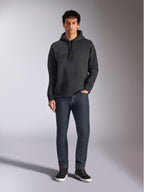 Alpinestars Emergent Oversized Hoodie, codzienna bluza streetwearowa, czarna z haftowanym logo 3D w tym samym kolorze, kaptur ze sznurkiem, kieszeń kangurka, oversizowy krój, model w ciemnoniebieskich jeansach i czarnych sneakersach.