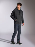 Alpinestars Emergent Oversized Hoodie, czarna bluza streetwearowa, tonalne haftowane logo 3D Astars na piersi, kieszeń kangurka, oversizowy krój, model w ciemnoniebieskich dżinsach i czarnych sneakersach