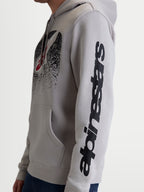Alpinestars Bluza Z Kapturem Obsessed, casualowa bluza motorsportowa unisex, szara z czarnymi detalami, widok z boku na modelu prezentujący pionowe logo na rękawie i gradientową grafikę MX na klatce piersiowej, konstrukcja z bawełny i poliestru z recyklingu.
