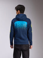 Alpinestars Obsessed Hoodie, granatowa polarowa bluza z kapturem, widok z tyłu z dużą jasnoniebieską grafiką z gradacją MX, żółty napis Alpinestars na rękawach, codzienna odzież uliczna inspirowana motorsportem