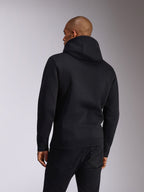 Alpinestars Ellipsoid Hoodie, czarna, widok z tyłu osoby ubranej w wkładaną przez głowę bluzę z miękkiego polaru z kapturem, długie rękawy z żebrowanymi mankietami i dołem, stylizacja z czarnymi dżinsami, codzienna odzież sportowa inspirowana sportami motorowymi
