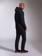 Alpinestars Ellipsoid Hoodie, czarna bluza typu streetwear, widok z tyłu na modelu, polarowa bluza z kapturem i ściągaczami, zestawiona z czarnymi spodniami i sneakersami, nowoczesny design inspirowany motorsportem
