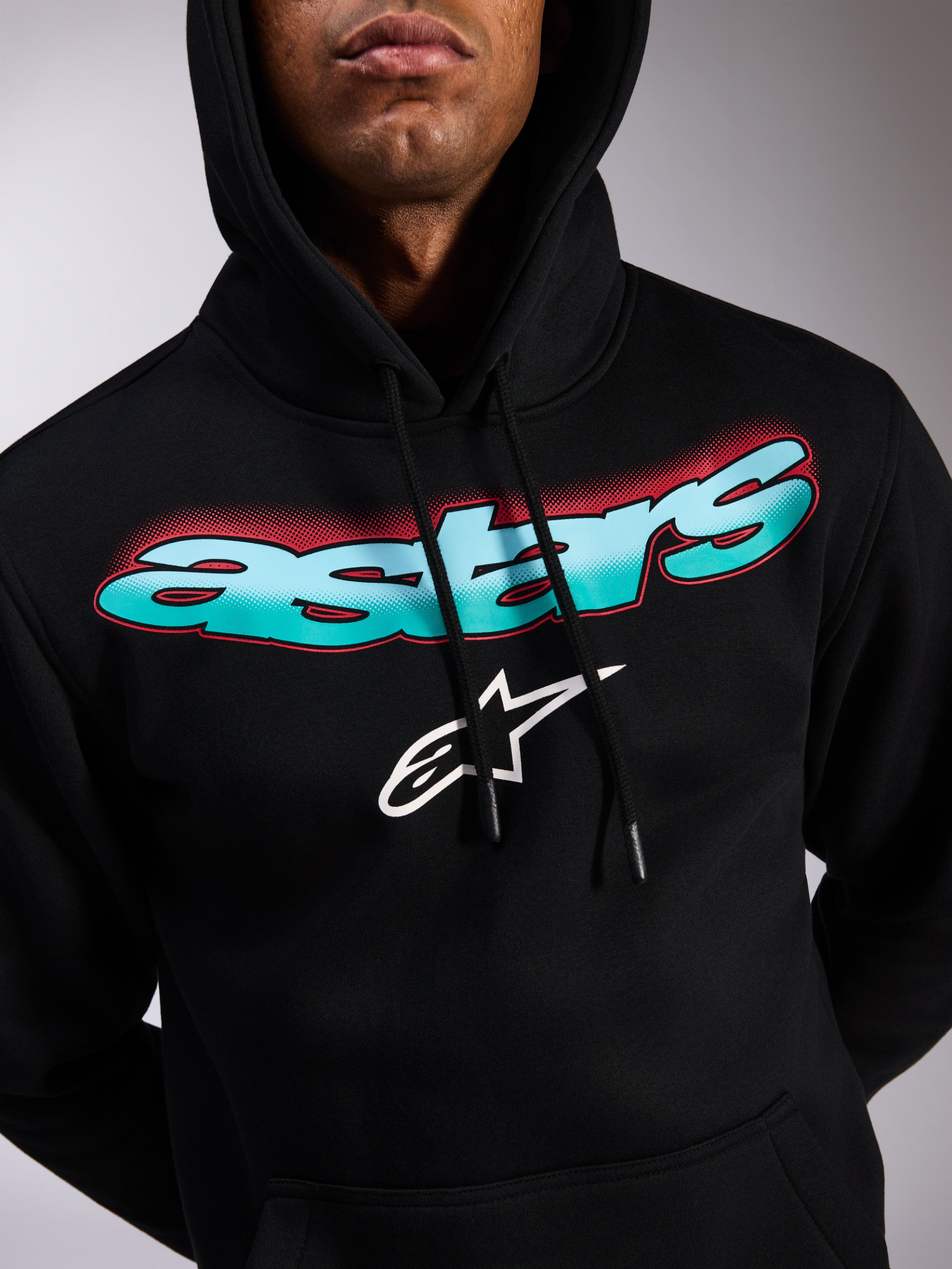Alpinestars Ellipsoid Hoodie, czarna bluza z polaru typu pullover, napis Astars z gradientem morskiego błękitu i niebieskiego z czerwonymi akcentami typu halftone, białe logo z gwiazdą, kaptur ze sznurkiem, codzienna odzież streetwearowa inspirowana motorsportem