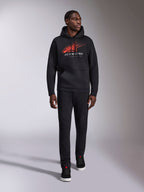 Alpinestars Pulse Hoodie, czarna casualowa bluza streetwear z kapturem, czerwono-szare logo Astars combo z efektem linii prędkości na klatce piersiowej, kaptur ze sznurkiem, przednia kieszeń typu kangurka, długie rękawy, zestawiona z czarnymi spodniami i sneakersami, design inspirowany motorsportem