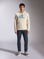 Alpinestars Pulse Hoodie, Off White, long sleeve pullover with drawstring hood, blue and black Astars Combo Logo with speed line fade, styled with dark jeans and sneakers, casual motorsport streetwear