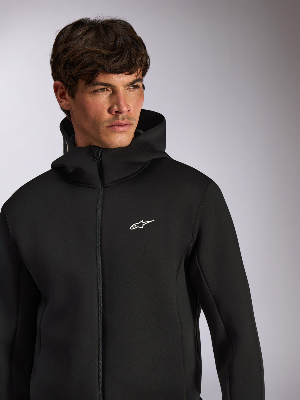 Alpinestars Cypher Hoodie, codzienna odzież sportowa, czarna rozpinana bluza z kapturem z białym logo Astars na piersi, wysoki krój kaptura, prezentowana na modelu