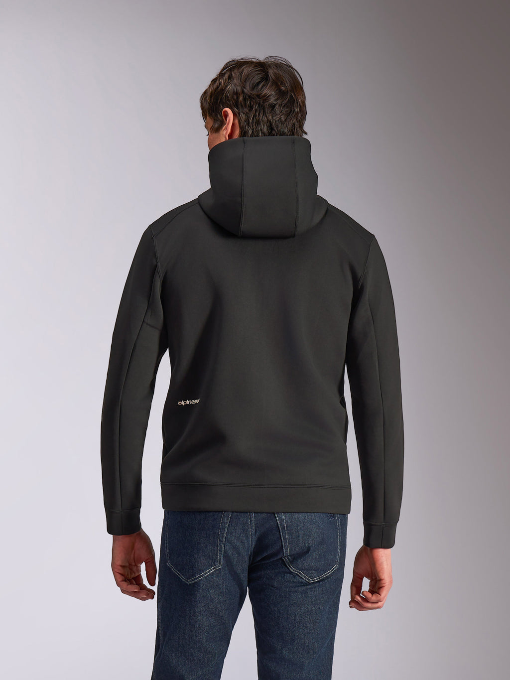 Alpinestars Cypher Hoodie, codzienna odzież sportowa, czarna, widok z tyłu z wysokim kapturem i małym białym logo Alpinestars na dole pleców, dwustronny materiał polarowy tri-blend, design inspirowany sportami motorowymi