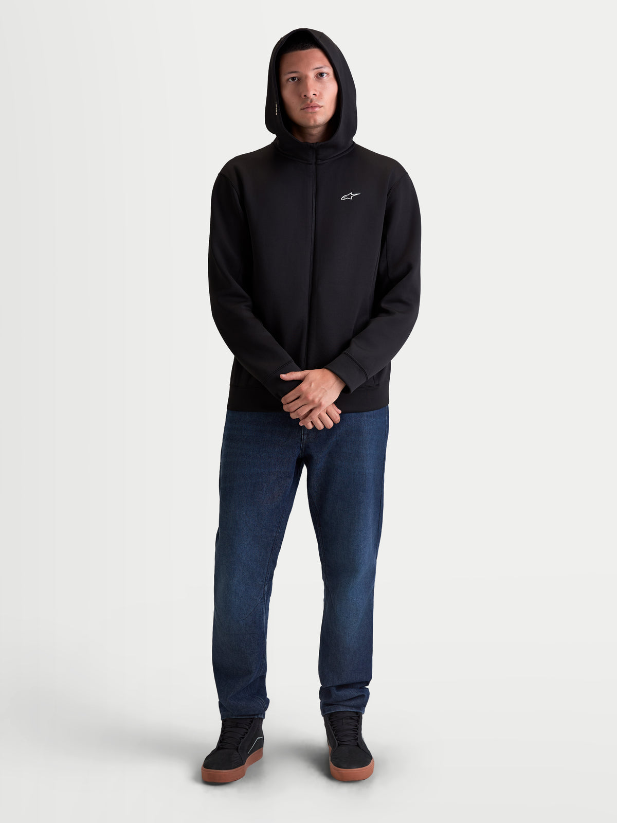 Alpinestars Cypher Hoodie, męska bluza z kapturem rozpinana, czarna, odzież sportowa, polar tri-blend, wysoki kaptur z podszewką z siateczki i małe białe logo Astars na piersi, prezentowana na modelu w codziennej stylizacji.