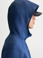 Alpinestars, bluza z kapturem Cypher, sportowa bluza polarowa z zamkiem z przodu, unisex, stalowoniebieska, wysoki kaptur z siatkową podszewką i bocznym logo Alpinestars, odzież sportowa inspirowana motorsportem, widok z profilu na modelu w czapce z daszkiem.