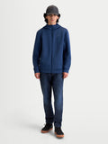 Alpinestars bluza z kapturem Cypher, męska bluza sportswear zapinana na zamek, stalowoniebieska, techniczna tkanina tri-blend, kaptur z wysokim kołnierzem i siatkową podszewką, kieszenie w szwach, casualowa odzież inspirowana motorsportem na modelu.