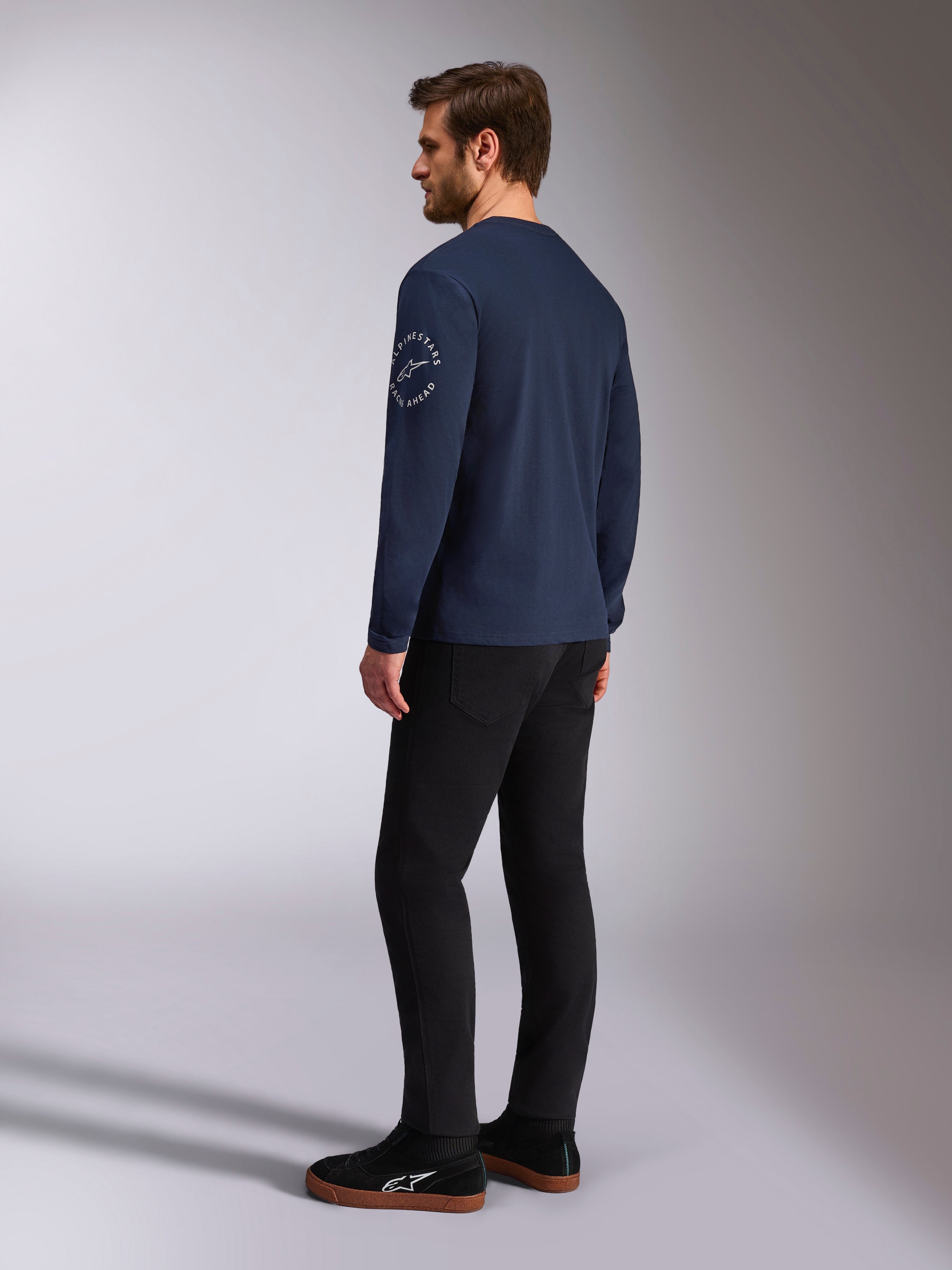 Alpinestars Mandatory CSF Tee - Long Sleeve, Navy, white circular logo on the sleeve, back-side view, worn with black pants and black sneakers, casual motorsport streetwear