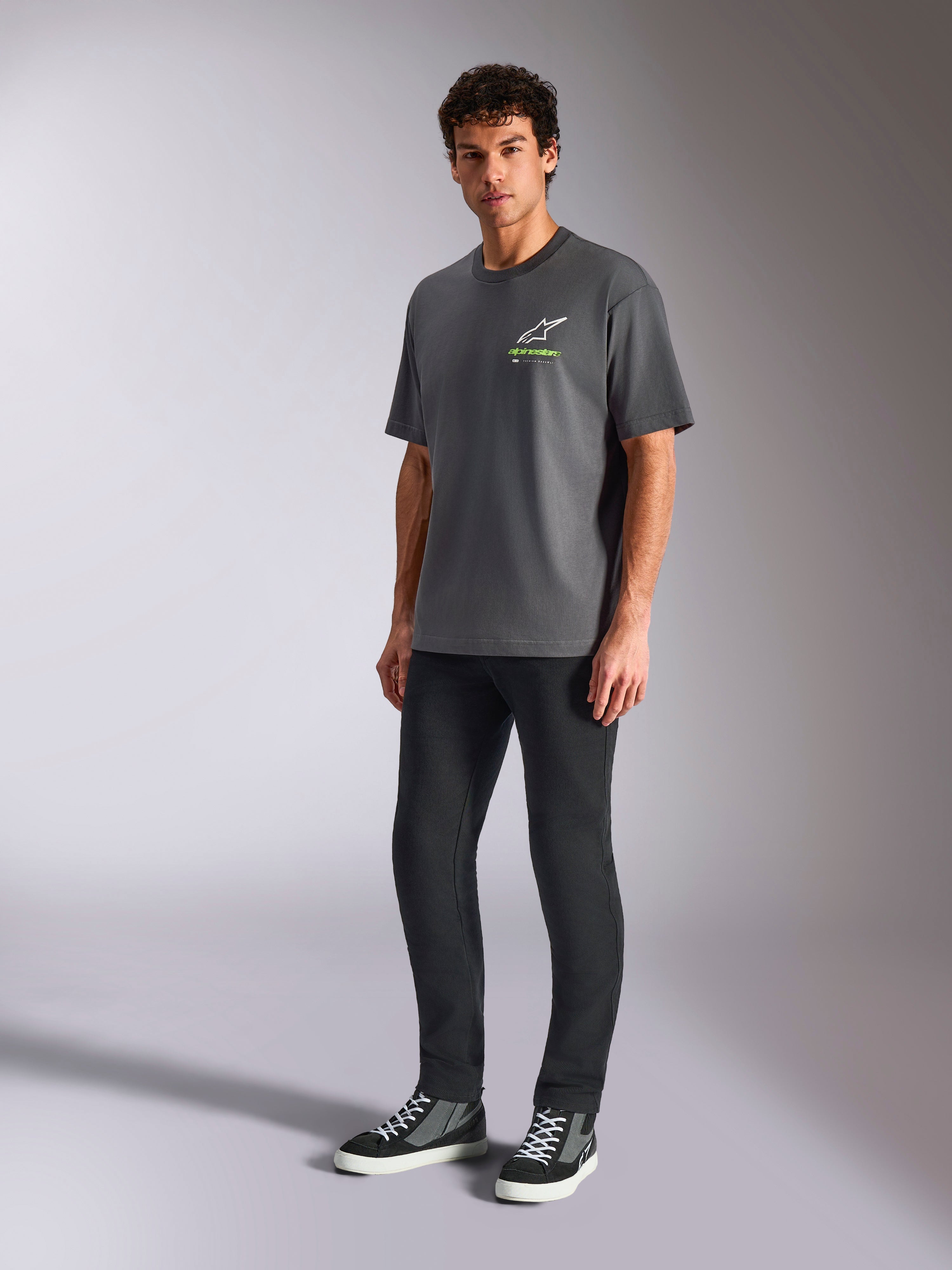 Alpinestars Overhang Oversized CSF Tee, Short Sleeve T-Shirt, Charcoal Gray, featuring white Astars logo and green text on chest, worn by model with black pants and sneakers, relaxed oversized fit, Casual Motorsport Streetwear