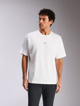 Alpinestars Focused Oversized CSF Tee, biała koszulka z krótkim rękawem, małe czarne logo Astars na piersi, luźny krój prezentowany na modelu, codzienna odzież streetwearowa w stylu motorsport