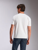Alpinestars Abus CSF Tee, koszulka z krótkim rękawem, biała, widok z tyłu na modela w gładkiej białej koszulce i ciemnoniebieskich dżinsach, codzienna odzież lifestylowa inspirowana sportami motorowymi
