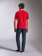 Alpinestars Authority CSF Tee, koszulka z krótkim rękawem, czerwona, widok z tyłu na modelu ubranym w ciemnoniebieskie dżinsy i czarne sneakersy, codzienna odzież streetwear inspirowana motorsportem