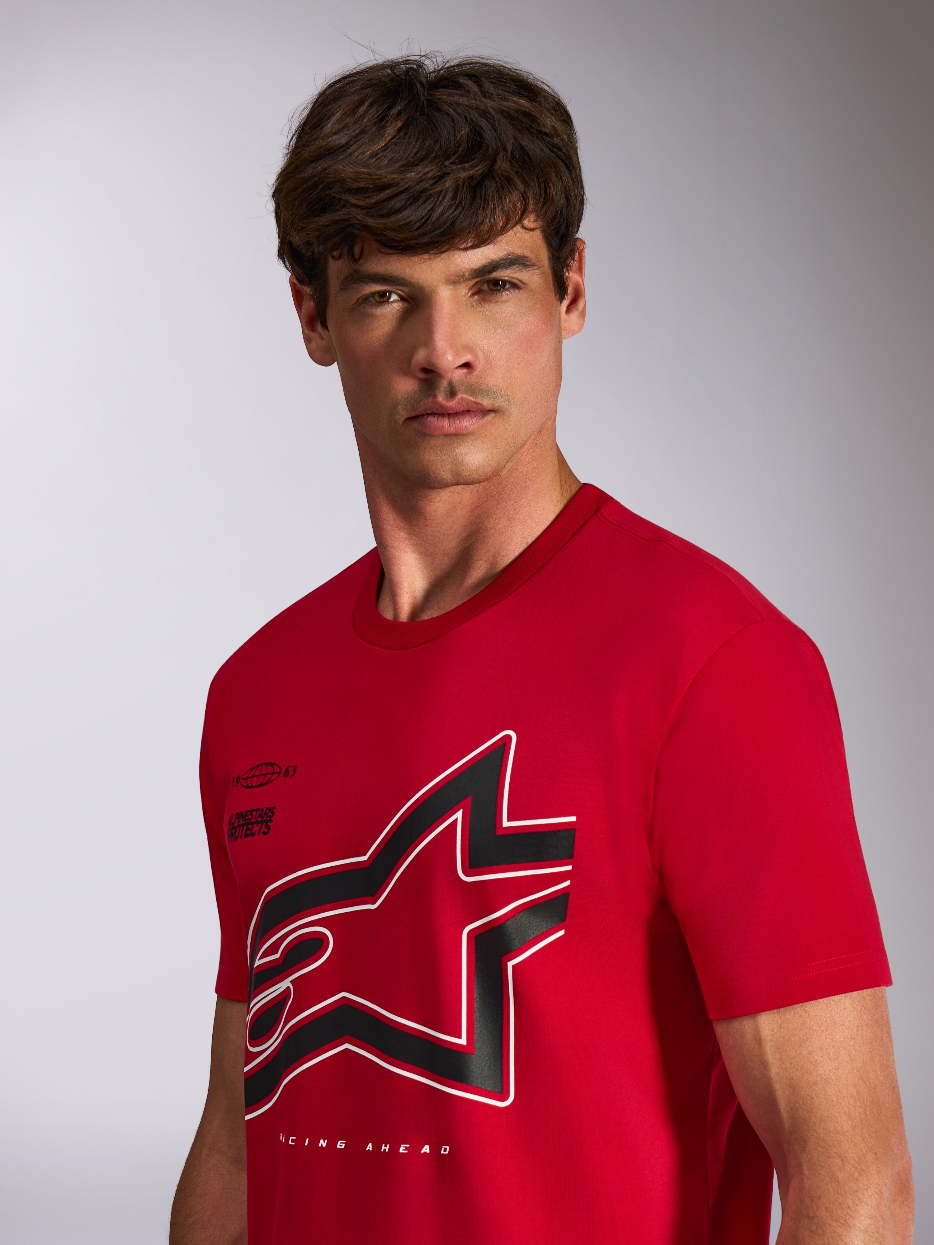 Alpinestars Authority CSF Tee, koszulka z krótkim rękawem, czerwona, duże przycięte czarno-białe logo Astars z konturem, prezentowana na modelu, codzienna odzież uliczna inspirowana sportami motorowymi