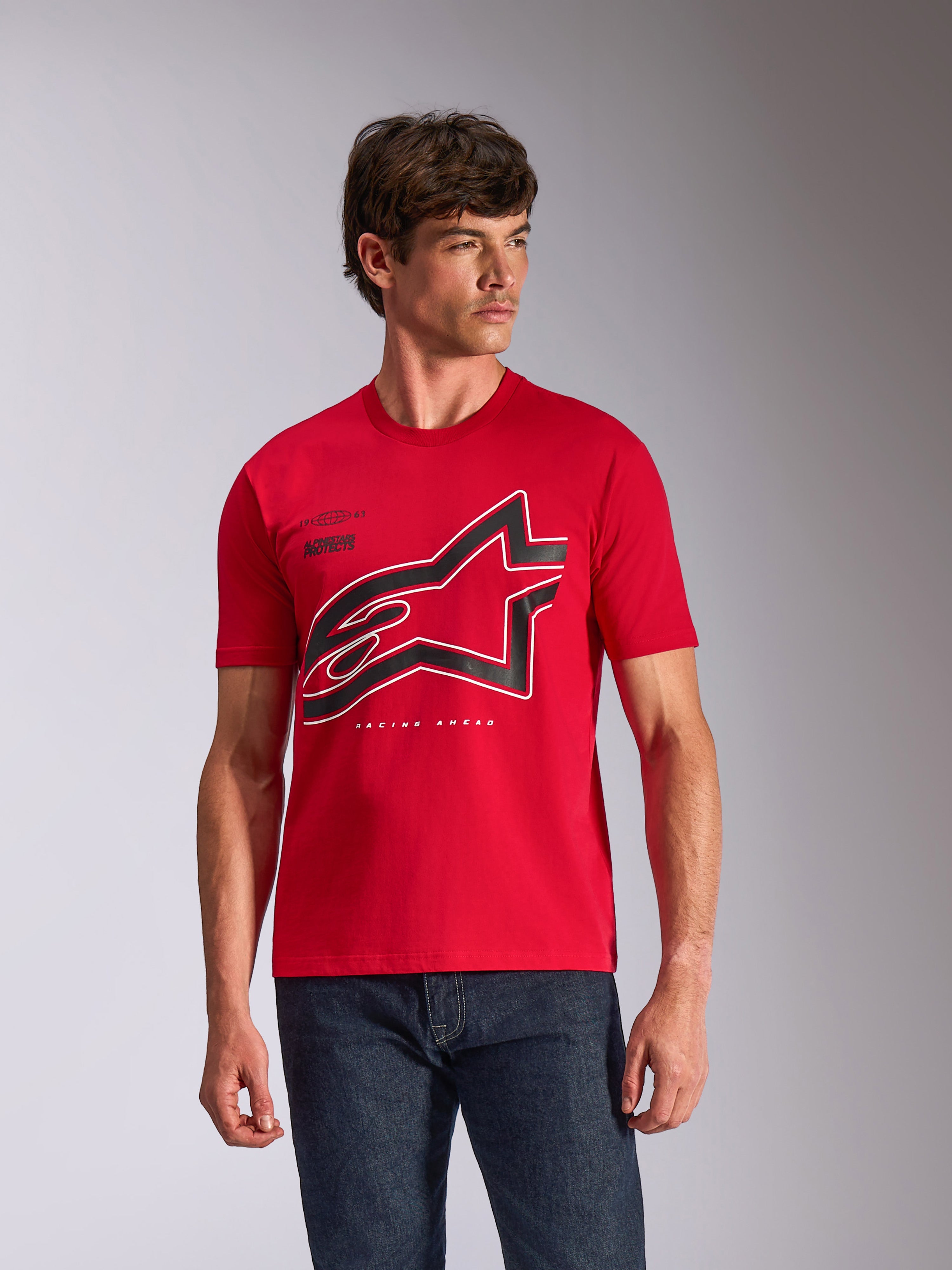 Alpinestars Authority CSF Tee, koszulka z krótkim rękawem, czerwona, duże czarno-białe konturowe logo Astars na klatce piersiowej, noszona przez modela z ciemnoniebieskimi dżinsami, codzienny streetwear inspirowany motorsportem